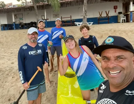 Equipe da Athēná Canoagem reunida à beira-mar
