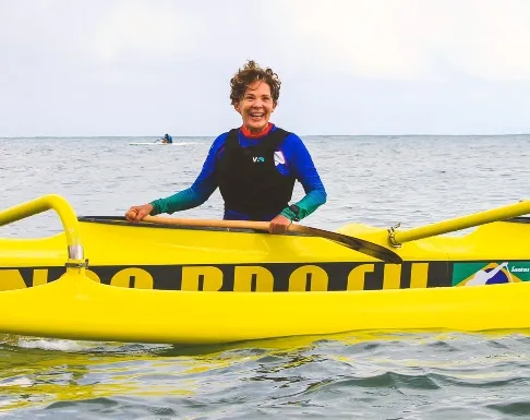 Integrante da equipe da Athēná Canoagem junto a uma canoa